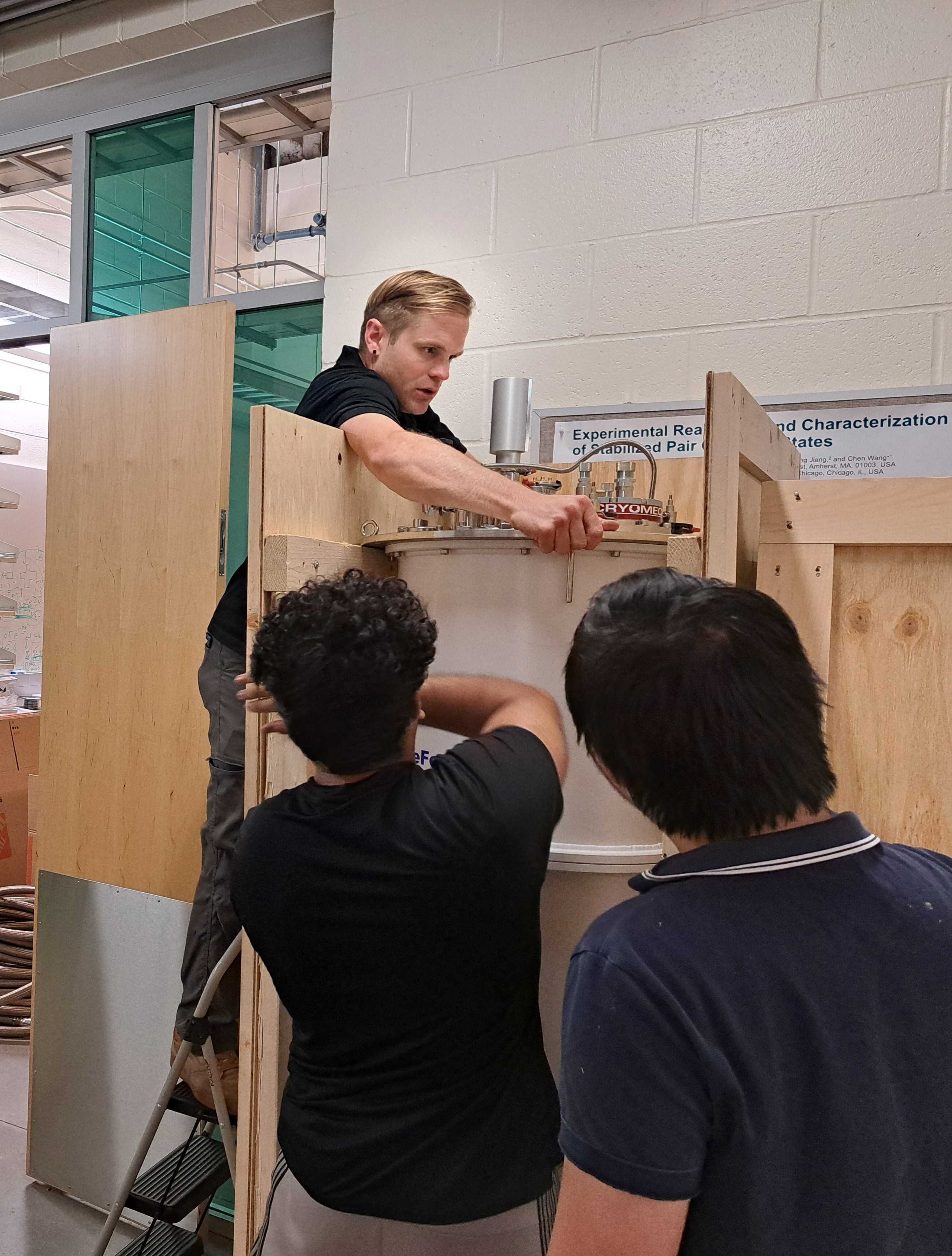 Lab members prepare a dilution refrigerator for its temporary transit enclosure.