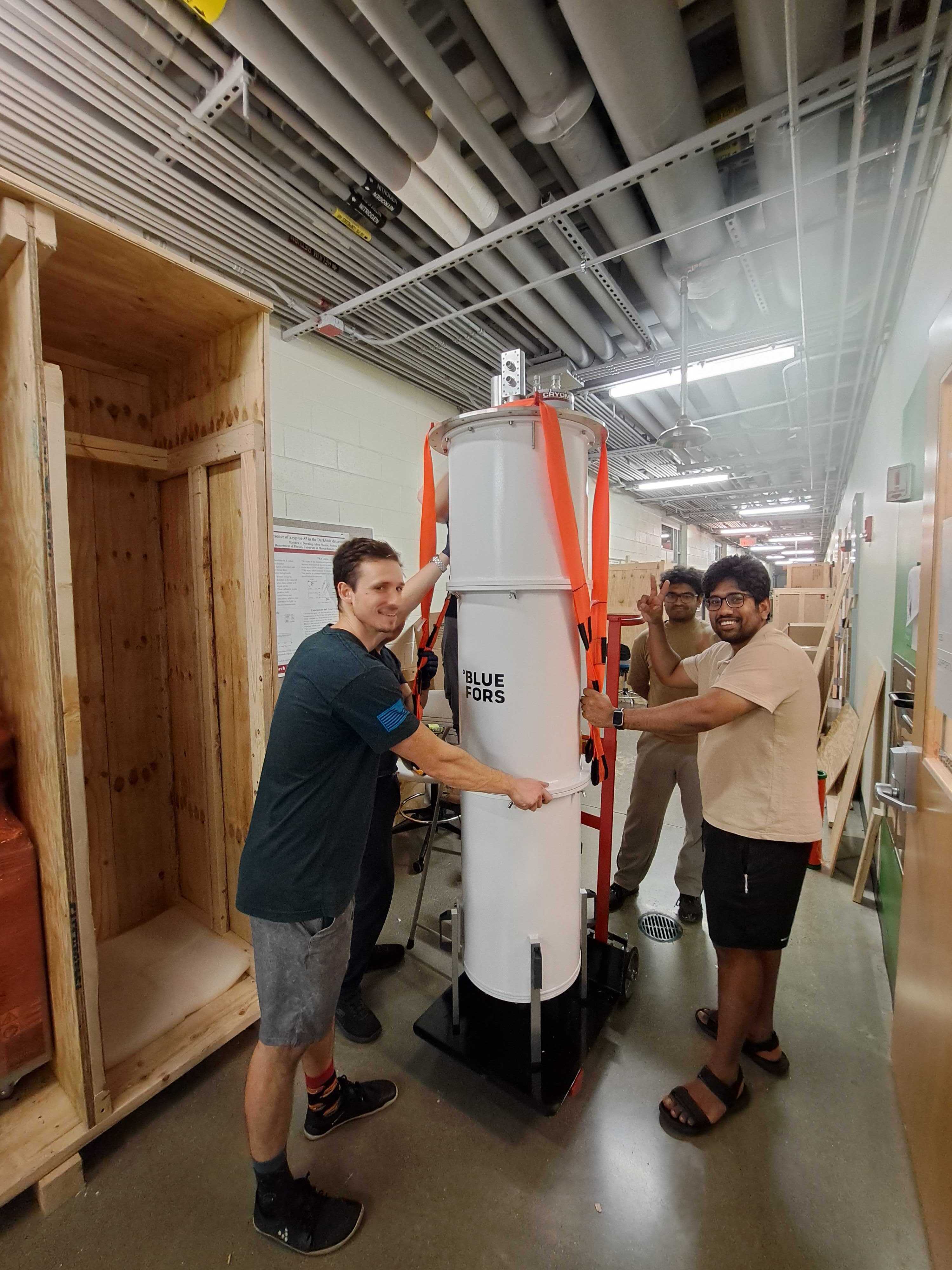 A dilution refrigerator being moved through the lab corridor for packing and transit.